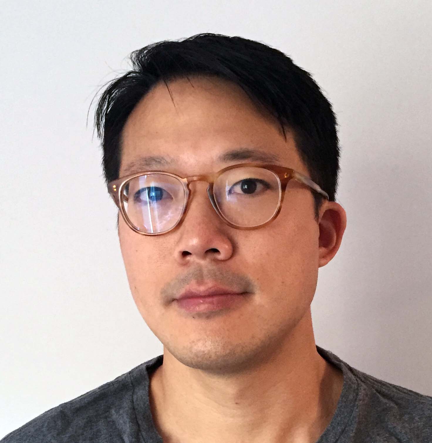 headshot of Kenneth Tam in gray t-shirt