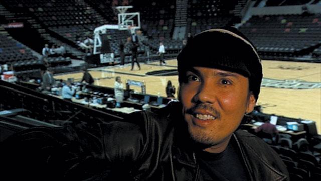 man takes selfie next to basketball court