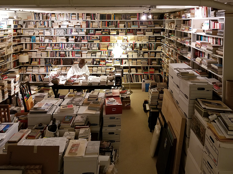 Man reads in room full of books