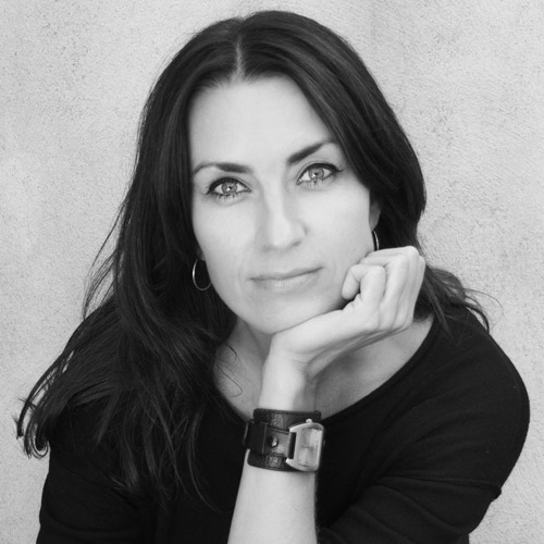 Katja Prins headshot with black shirt and hoop earrings