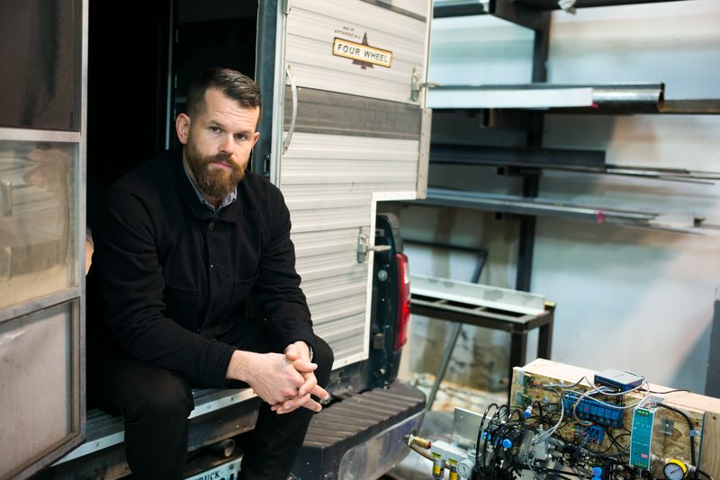 photo portrait of Matthew Day Jackson sitting in trailer