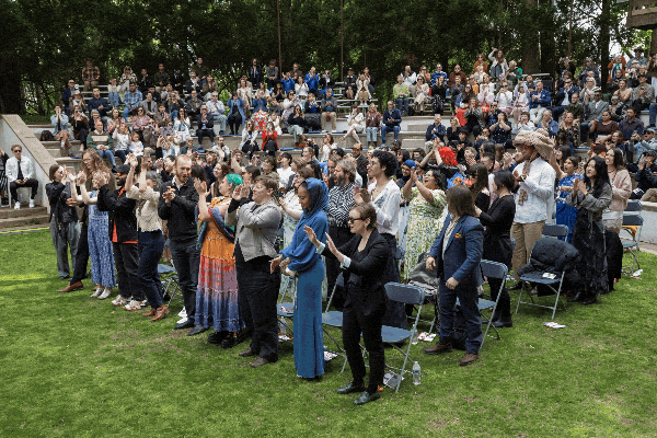 Rotating images from Commnencement 2026 at Cranbrook Academy of Art. Photos show students smiling and hugging their Artist-in-Residence as they cross the stage and receive their "faux diplomas."
